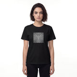 Front view of a black women’s t-shirt by HOLO streetwear. Scratchy Lines features a square in the center of the chest. In a dark grayscale, the design looks like a surface has been scratched diagonally, symmetrically and mirrored. Minimalist style.