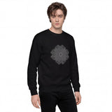 A man wearing a black crewneck sweatshirt with a gray geometric mandala-style graphic printed on the chest, paired with black pants, set against a plain white background.