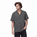 Front left view of a black and gray men’s all-over printed button shirt by HOLO Streetwear, featuring the Zig Zag design. The pattern consists of parallel zigzag lines alternating between black and gray, almost creating a optical illusion effect at a certain distance. A bold streetwear piece that combines movement and contrast for a dynamic look.